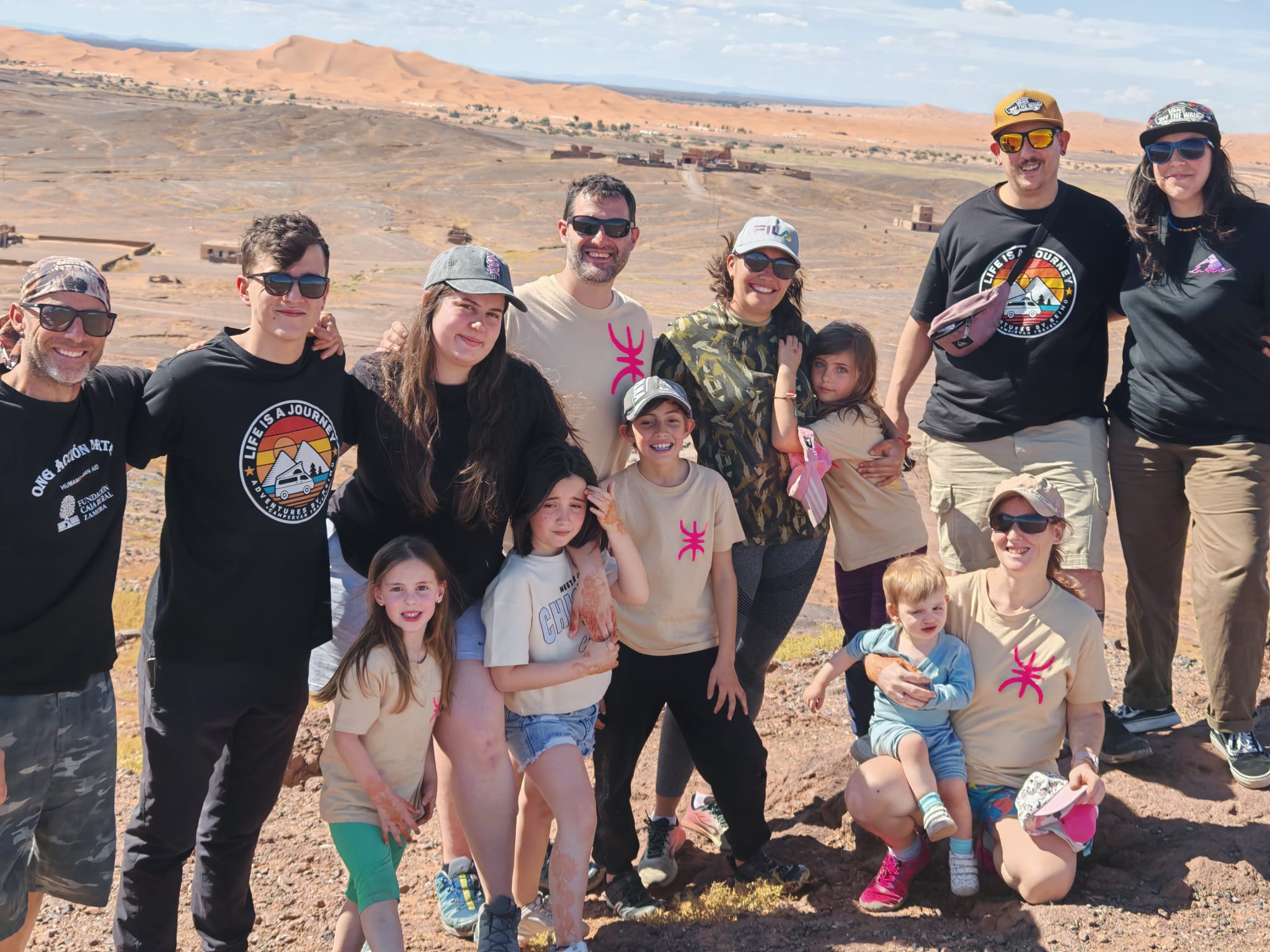 Grupo de familias viajando en autocaravana con las dunas del Erg Chebbi al fondo