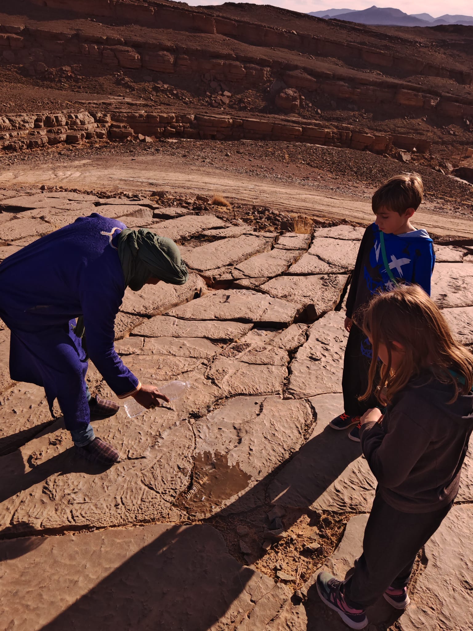 Guía local mostrando fósiles a los niños en Gara Medouar, Marruecos