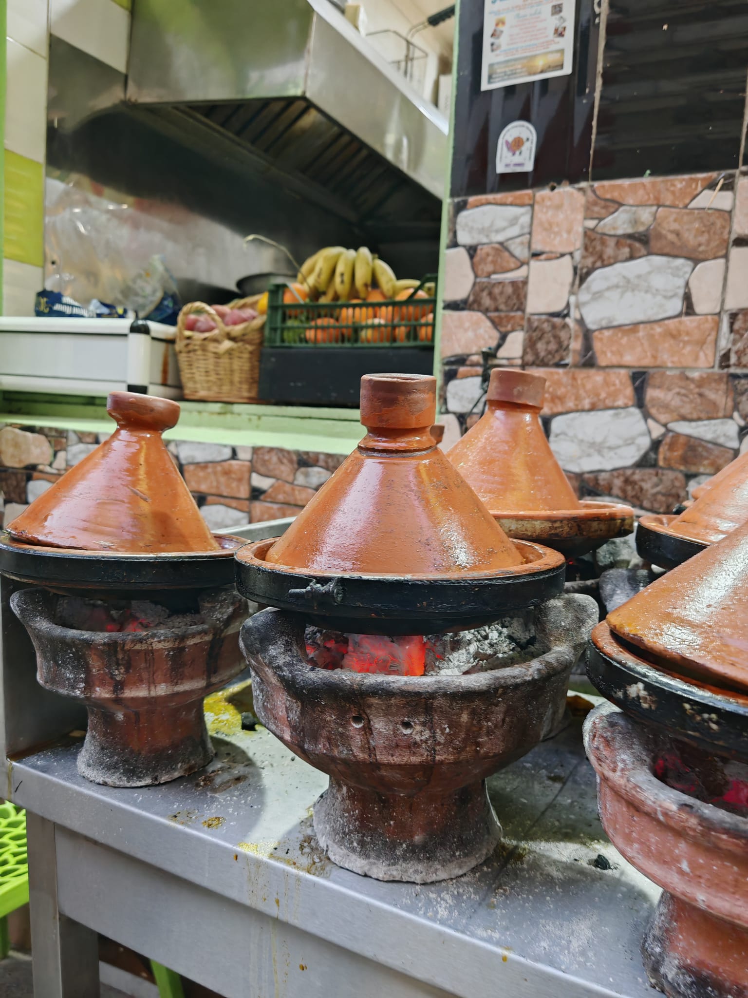 Tajines cocinándose sobre brasas en un taller de cocina marroquí
